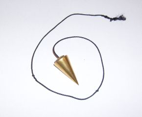 A cone-shaped brass pendulum on a length of dark cord, lying on a white surface